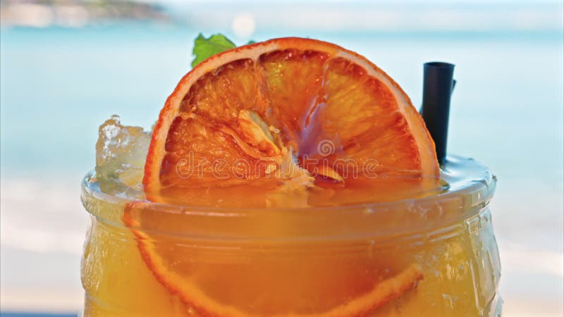Gros plan d'un cocktail orange sur une tablette banque de vidéos