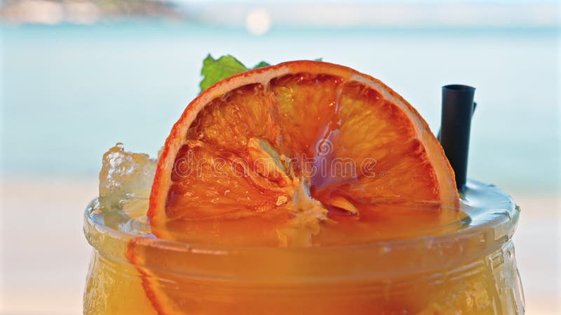 Gros plan d'un cocktail orange sur une tablette clips vidéos