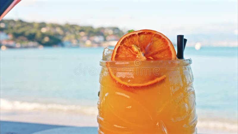 Gros plan d'un cocktail orange sur une tablette banque de vidéos