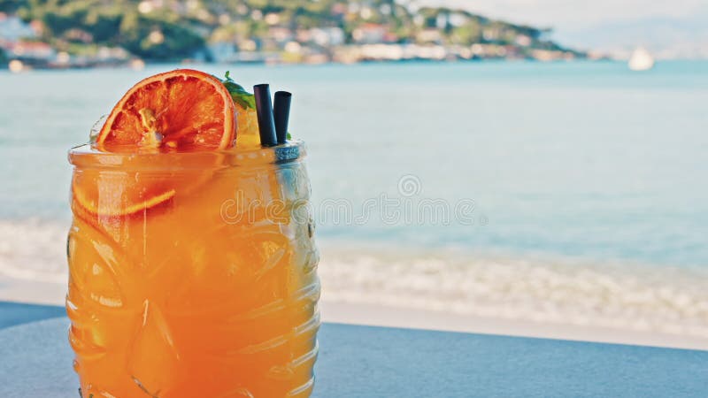 Gros plan d'un cocktail orange sur une tablette banque de vidéos