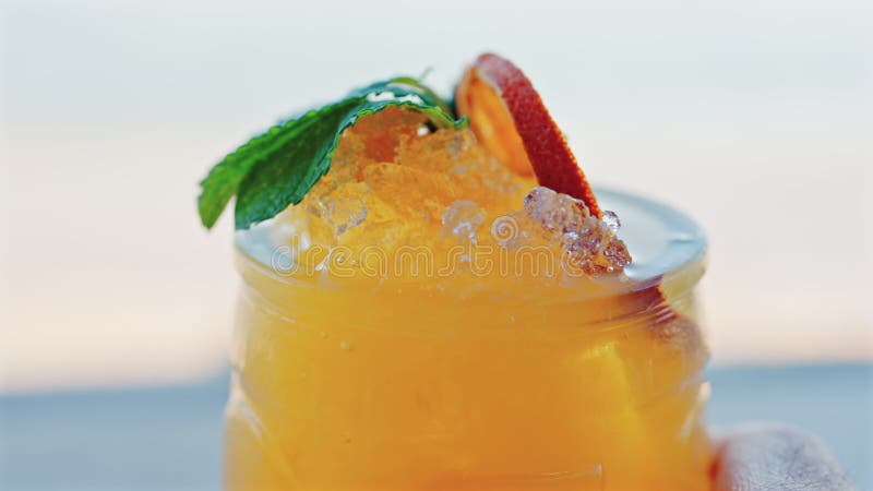 Gros plan d'un cocktail orange sur une tablette banque de vidéos
