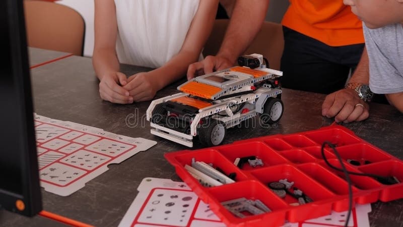 Gros plan d'un groupe d'enfants jouant avec des robots dans une école de robotique. clips vidéos