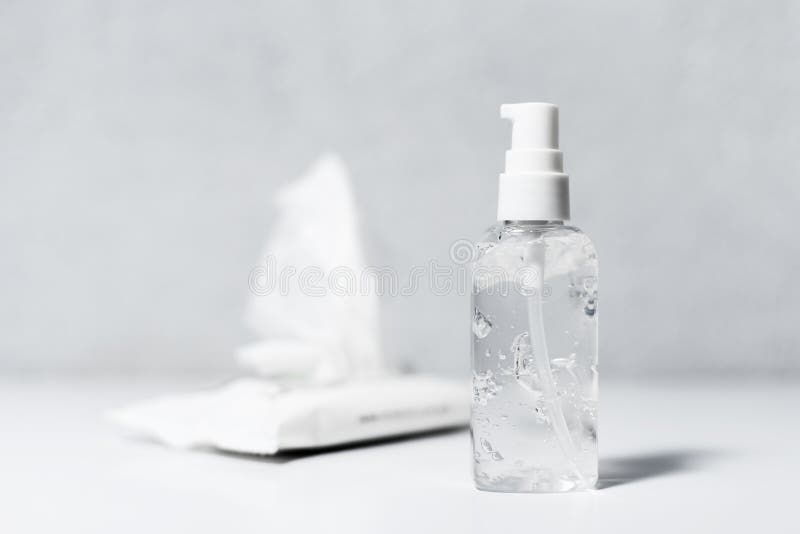 Close-up of dispenser bottle with sanitizer antibacterial gel, and wipes wet on white table, coronavirus prevention. Close-up of dispenser bottle with sanitizer antibacterial gel, and wipes wet on white table, coronavirus prevention