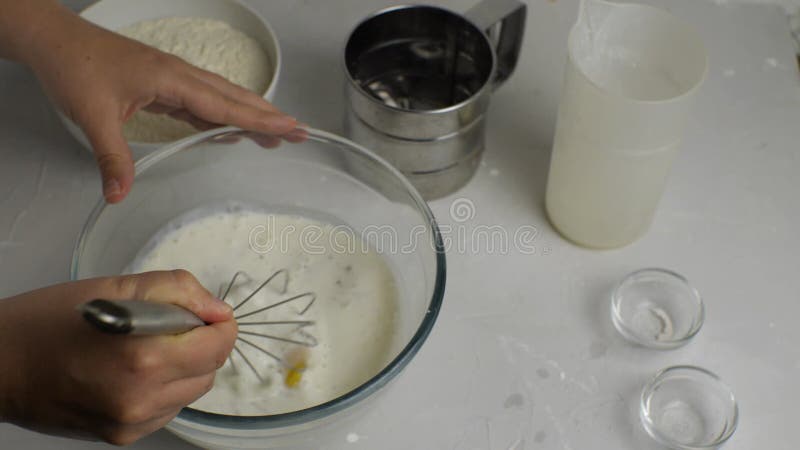 Gros plan d'une femme cassant les oeufs de poulet à la main dans un bol transparent de kéfir clips vidéos