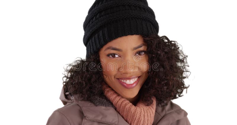 Gros plan d'une jolie femme noire en manteau d'hiver souriant à la caméra en studio banque de vidéos