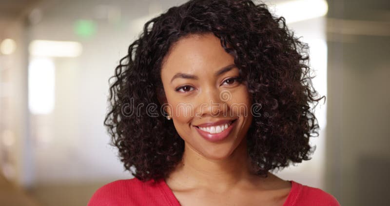 Gros plan de la mignonne femme noire aux cheveux bouclés et beau sourire à l'intérieur banque de vidéos