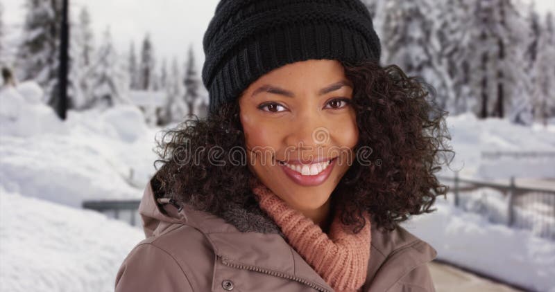 Gros plan de la mignonne noire femelle dehors dans la neige souriant à la caméra banque de vidéos