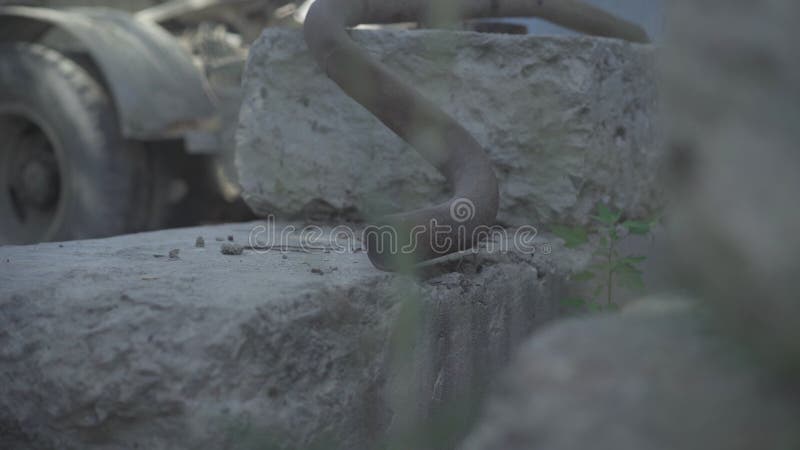 Gros plan de tuyau métallique sur de grandes briques avec le transport cassé au fond. Ruines de ancienne usine abandonnée dehors. banque de vidéos