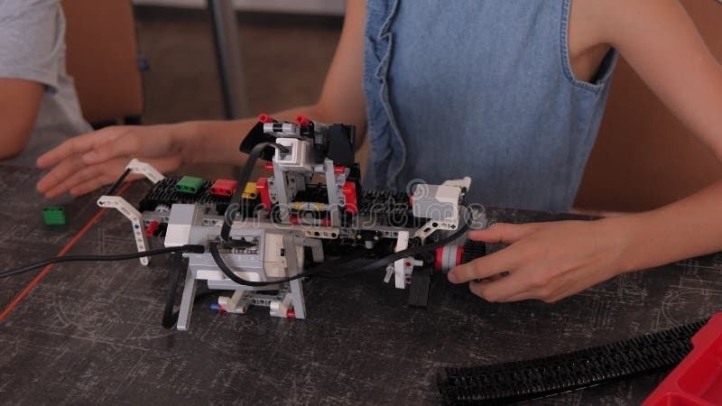 Gros plan du groupe d'enfants qui jouaient avec les robots rassemblés dans une école de robotique banque de vidéos