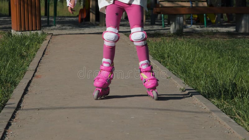 Petite Fille Dans Patins À Roulettes Au Parc Banque D'Images et