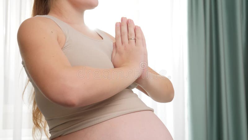 Gros plan filtrant le tir de la position de sourire de femme enceinte dans la pose de yoga ou de l'asana à la grande fenêtre. Conc banque de vidéos