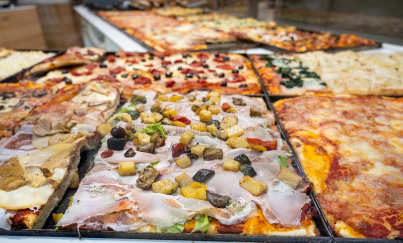 Grosses Pizzasortiment mit Käse und Prosciutto in einem Pizzageladen in Bergamo Italien lizenzfreies stockfoto