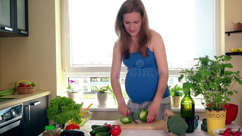 Grossesse et nutrition La femme enceinte a coupé des légumes de paprika sur la table de cuisine