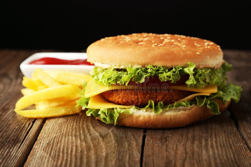 Grote hamburger op bruine houten achtergrond stock afbeelding Grote hamburger op bruine houten achtergrond stock afbeelding