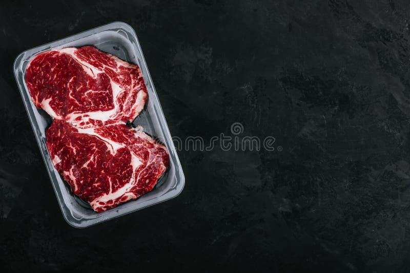 Ground Beef Steak in Vacuum Packaging on Dark Stone Background Stock