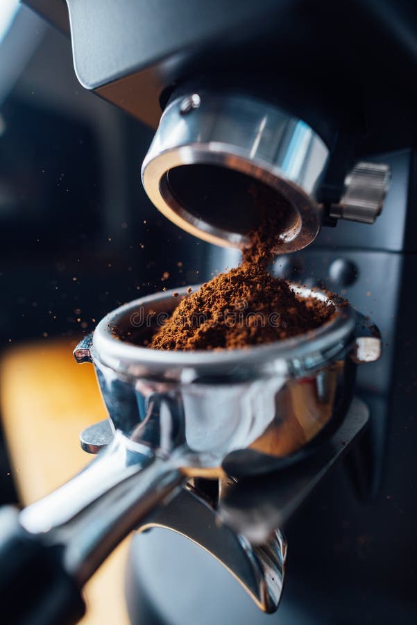 Ground Coffee Pouring into a Portafilter with a Grinder Stock Image