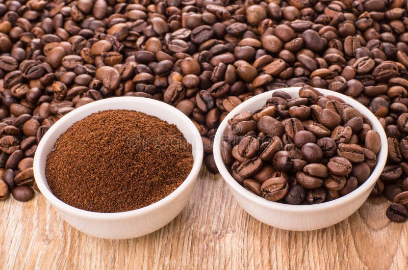 Ground Coffee and Roasted Coffee Beans in Bowls on Table Stock Photo