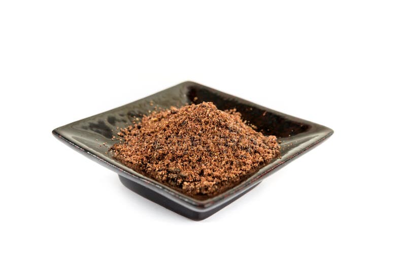 Ground Dried Sumac Berry Powder on a Black Ceramic Plate Stock Photo