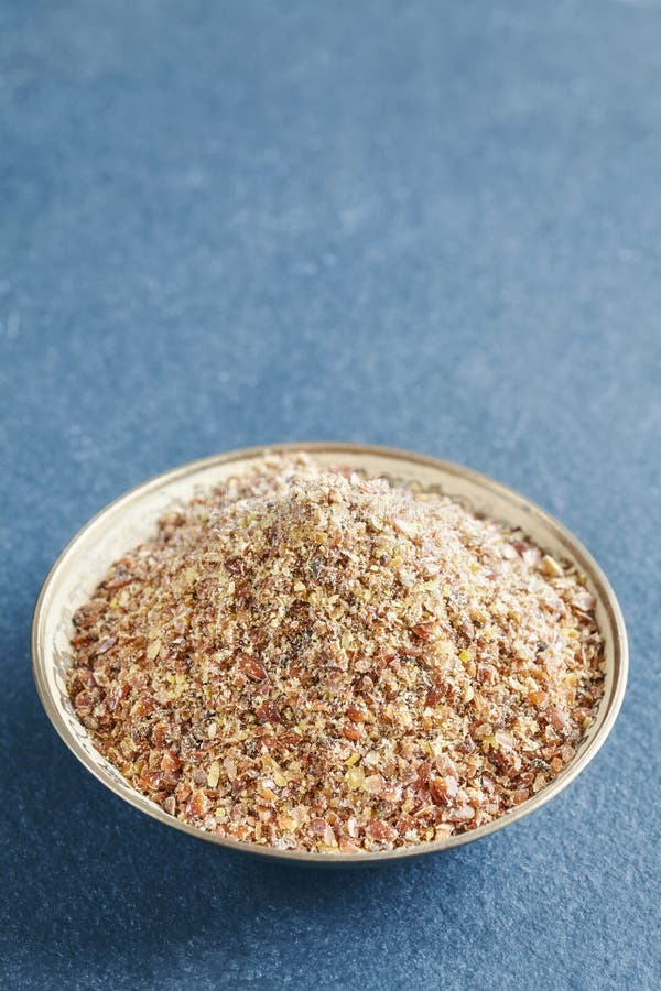 Ground flaxseed in a bowl on a slate background, selective focus, space for text royalty free stock image