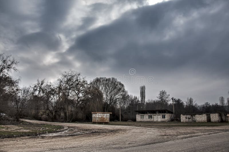 ground road in village in winter countryside the evening sunlight. atmospheric rural moment. Old house at road with trees at Gazak