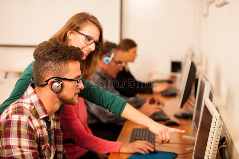 Group of adults learning computer skills. Intergenerational tran royalty free stock photo