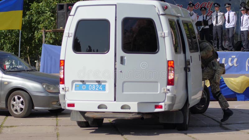 Group of armed soldiers in masks climbed into large white car on street