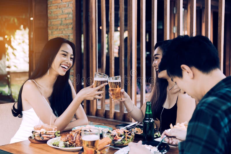 Group of Asian People Cheering Beer at Restaurant Happy Hour in Stock