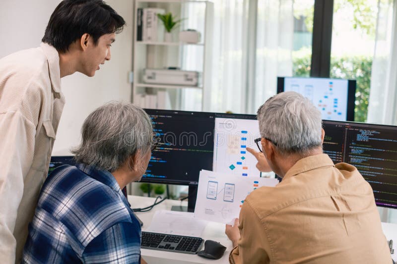 Group of asian senior in a collaborative software development analyzing flowcharts during a bootcamp training royalty free stock image