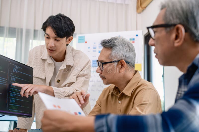 Group of asian senior in a collaborative software development analyzing flowcharts during a bootcamp training stock images