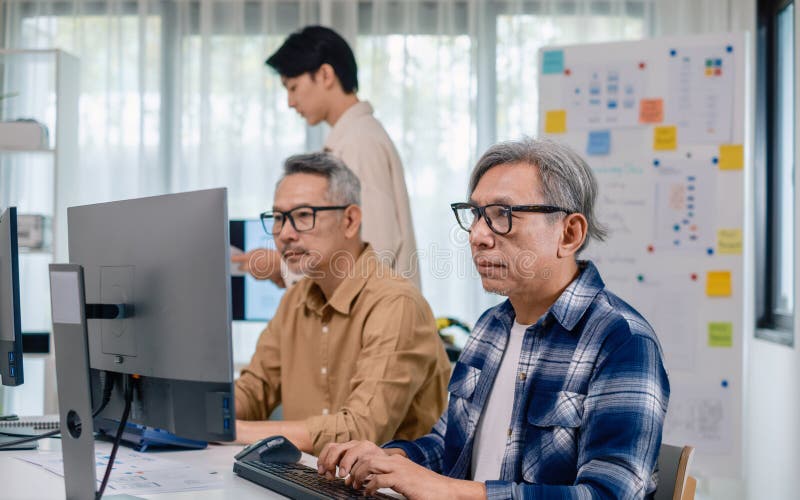 Group of asian senior in a collaborative software development analyzing flowcharts during a bootcamp training stock photography