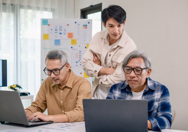 Group of asian senior in a collaborative software development analyzing flowcharts during a bootcamp training royalty free stock photos