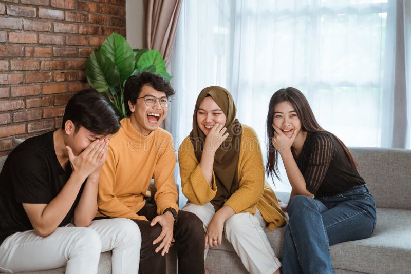 Group of Asian Young People Sitting Together on the Couch Laughing