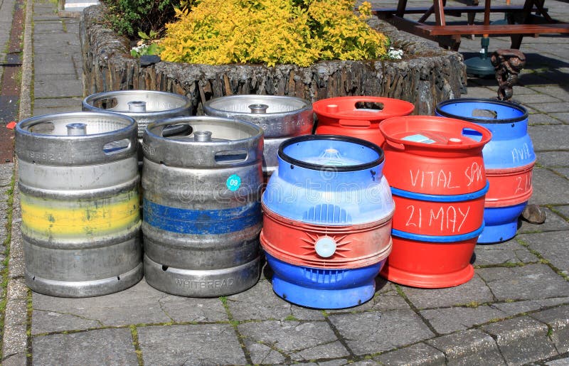 Group of Assorted Beer Barrels on a Pavement Editorial Stock Image
