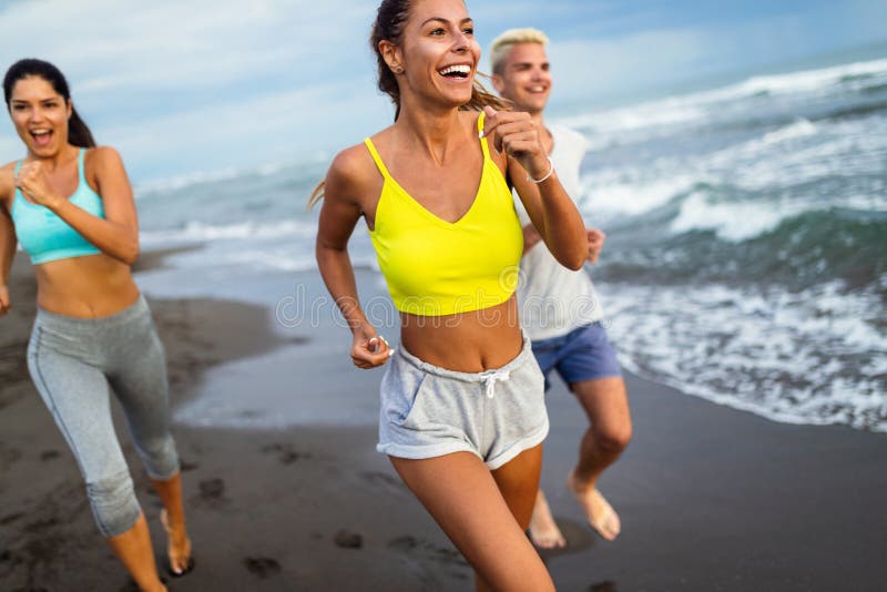 Group of athletes running on ocean front. Friends in sportswear training together outdoors. stock photo Group of athletes running on ocean front. Friends in sportswear training together outdoors. stock photo