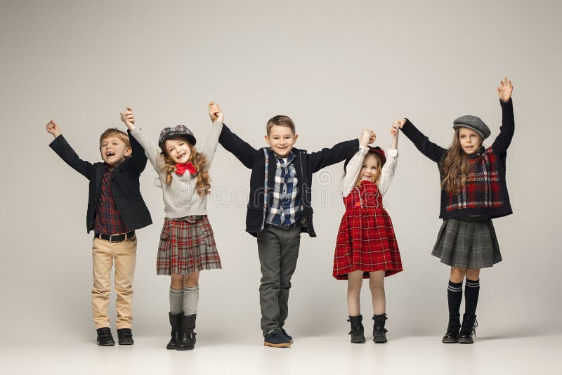 The group of beautiful girls and boys on a pastel background