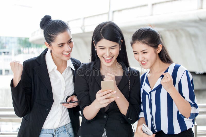 group of beautiful young women friends using a smart phone and laughing outdoors .three girl exciting business online stock image group of beautiful young women friends using a smart phone and laughing outdoors .three girl exciting business online stock image