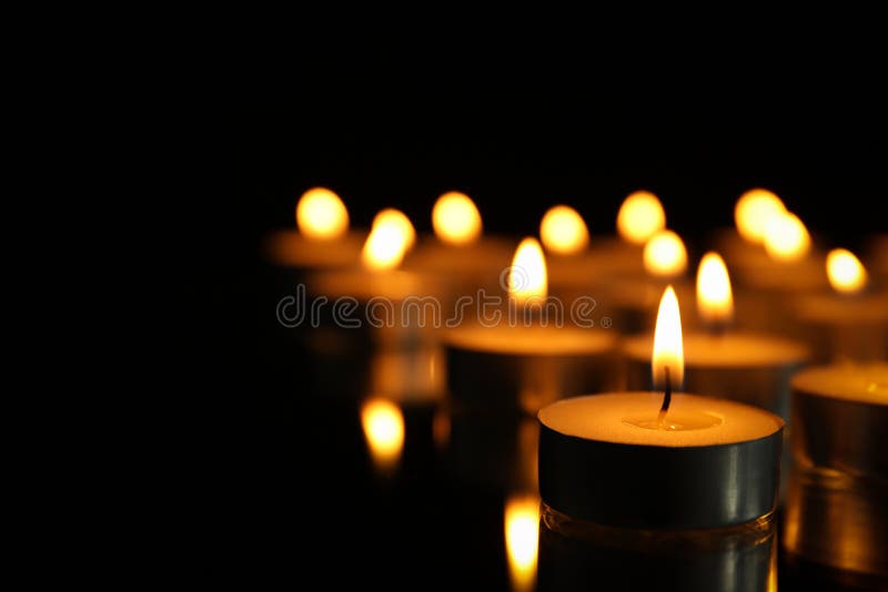 Group of burning candles on black background stock photography
