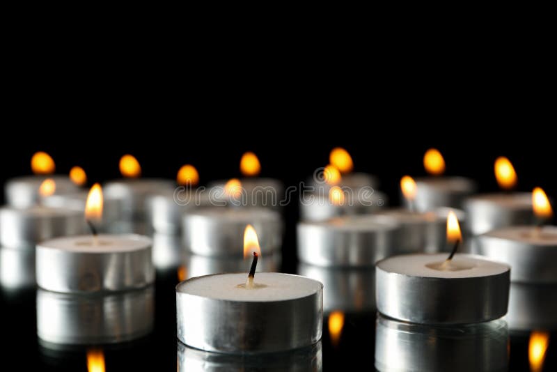 Group of burning candles on black background stock photos