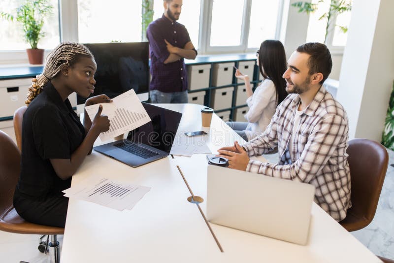 Group of business mixed race partners discussing strategies at meeting in office