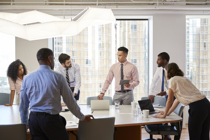 Group of Business Professionals Standing at Meeting Around Table in