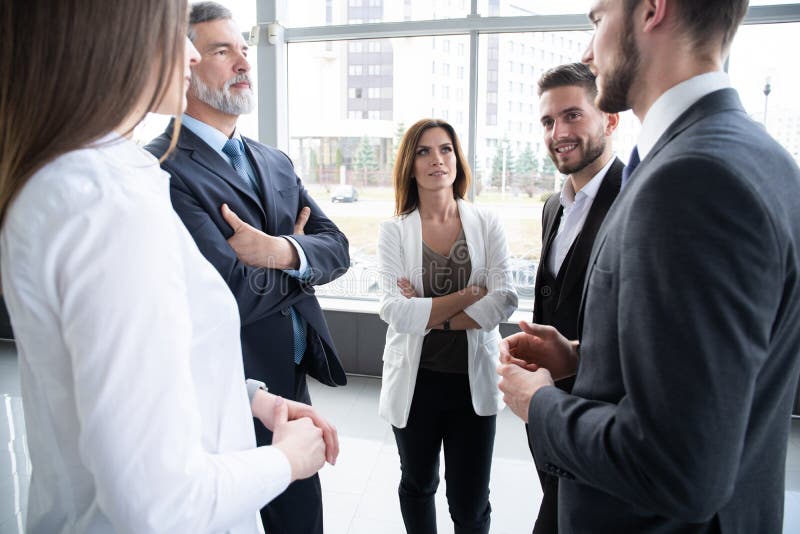 Group of Busy Business People Concept. Business team discussing work in office building hallway.