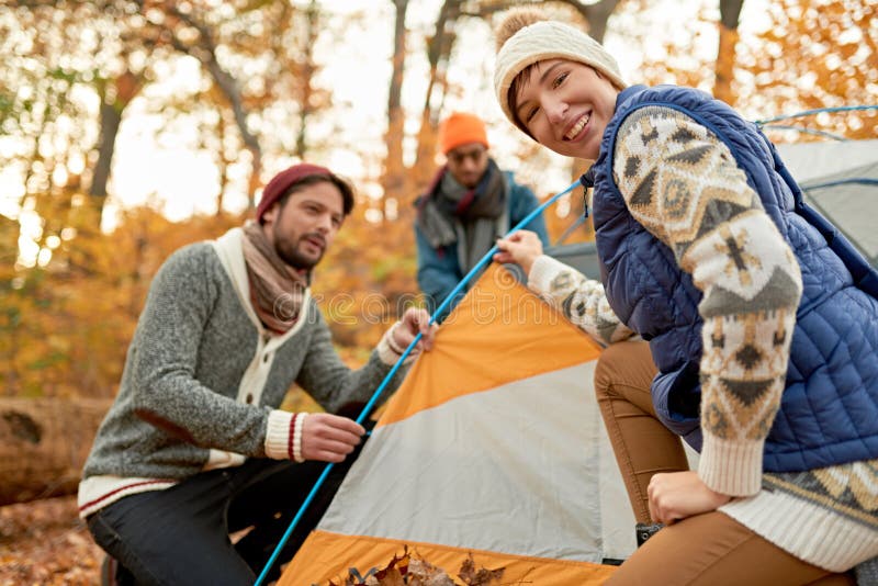 Group of Canadian Hikers Setting Up a Tent in a Fall Forrest Stock
