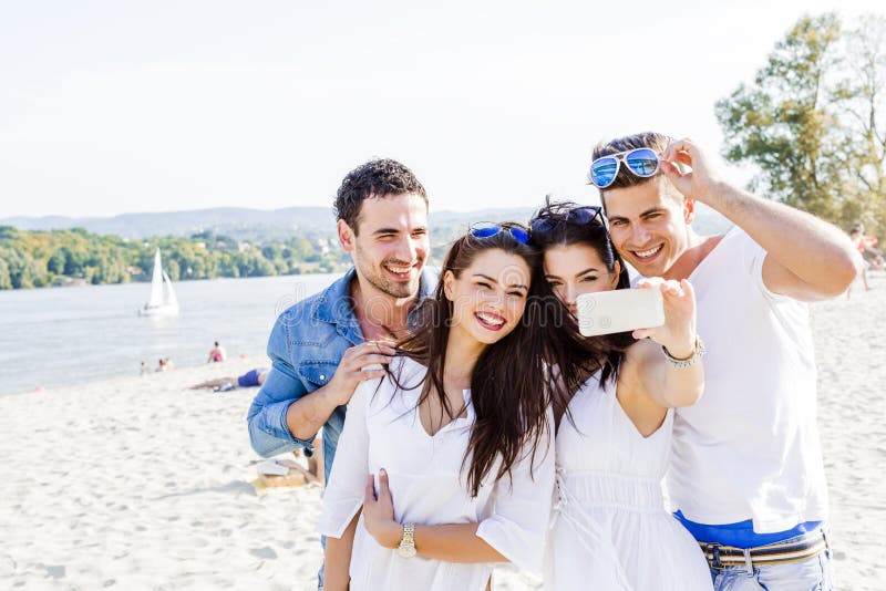 Group of cheerful and beautiful young people taking photos of th stock images