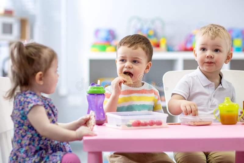 Group of children eating healthy food in daycare centre stock images Group of children eating healthy food in daycare centre stock images