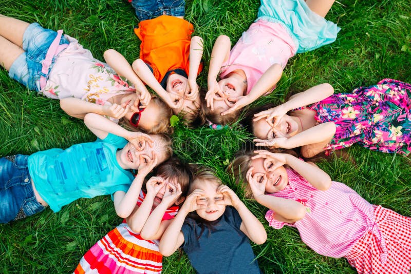 A group of children lying on the green grass in the Park. The interaction of the children. royalty free stock photography A group of children lying on the green grass in the Park. The interaction of the children. royalty free stock photography