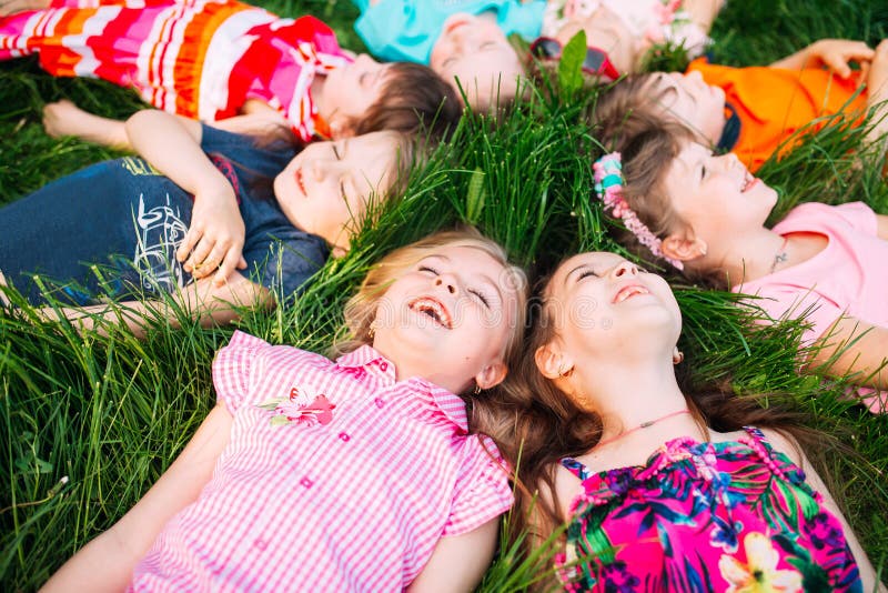 A group of children lying on the green grass in the Park. The interaction of the children. royalty free stock images A group of children lying on the green grass in the Park. The interaction of the children. royalty free stock images