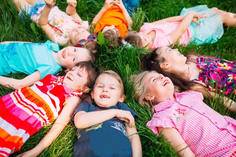 A group of children lying on the green grass in the Park. The interaction of the children. stock photography A group of children lying on the green grass in the Park. The interaction of the children. stock photography