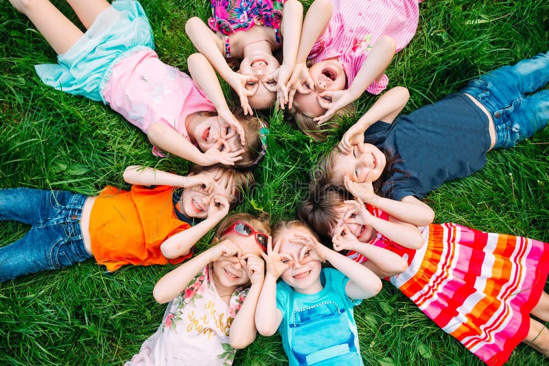 A group of children lying on the green grass in the Park. The interaction of the children. royalty free stock image A group of children lying on the green grass in the Park. The interaction of the children. royalty free stock image