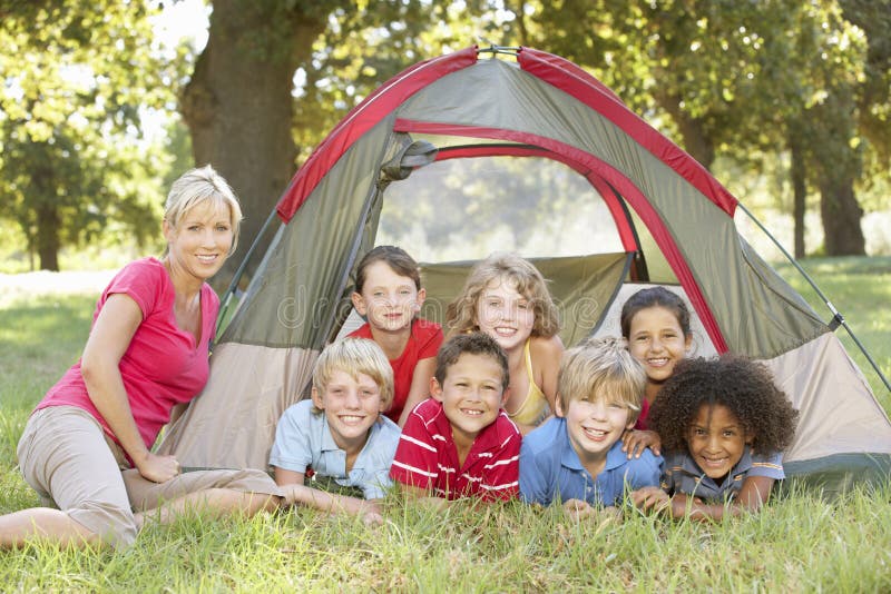 Group Of Children With Mother Having Fun In Tent In Countryside royalty free stock photography Group Of Children With Mother Having Fun In Tent In Countryside royalty free stock photography