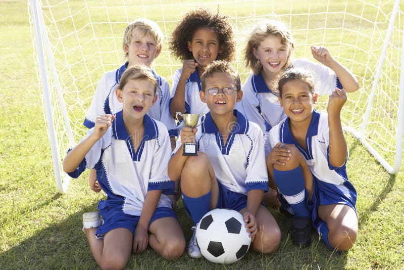 Group Of Children In Soccer Team Celebrating With Trophy Stock Photo